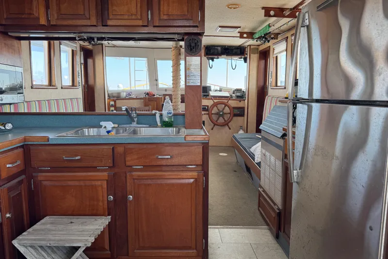 Slide: The Image of Interior of a 1985 custom Bill Holland trawler with wooden cabinetry and nautical decor. - 20