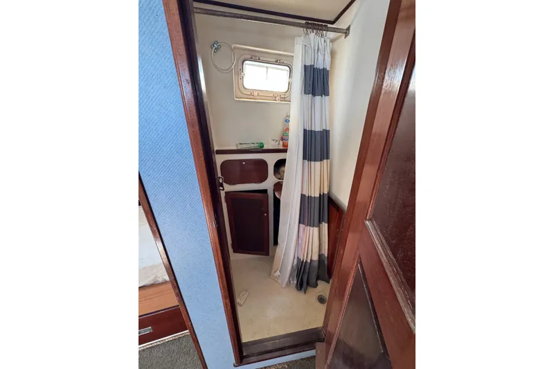 Slide: The Image of Interior of 1985 custom Bill Holland trawler bathroom with shower curtain and porthole window. - 14
