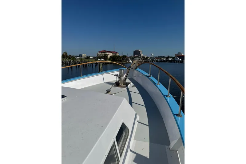 Slide: The Image of 1985 custom Bill Holland trawler deck with cityscape background and clear blue sky. - 4