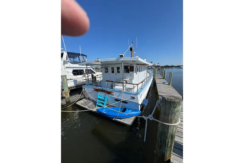 Slide: The Image of 1985 custom Bill Holland trawler docked at a marina under clear blue skies. - 2