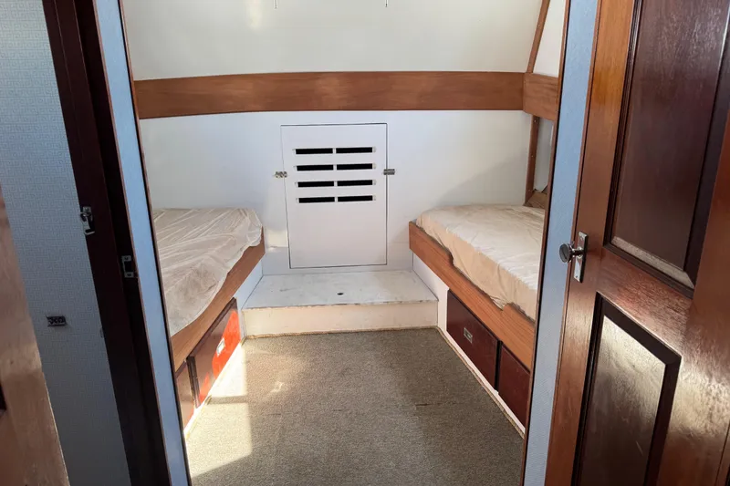 Slide: The Image of Interior cabin of a 1985 custom Bill Holland trawler with twin beds and wooden accents. - 17