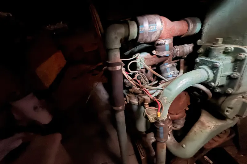 Slide: The Image of Engine room of a 1985 custom Bill Holland trawler, showcasing pipes and mechanical components. - 9