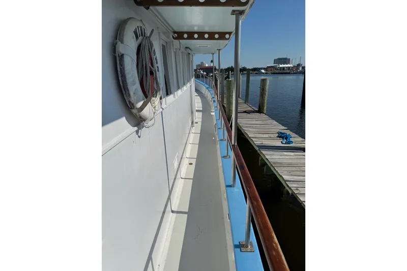 Slide: The Image of Side view of a 1985 custom Bill Holland trawler docked at a marina. - 5