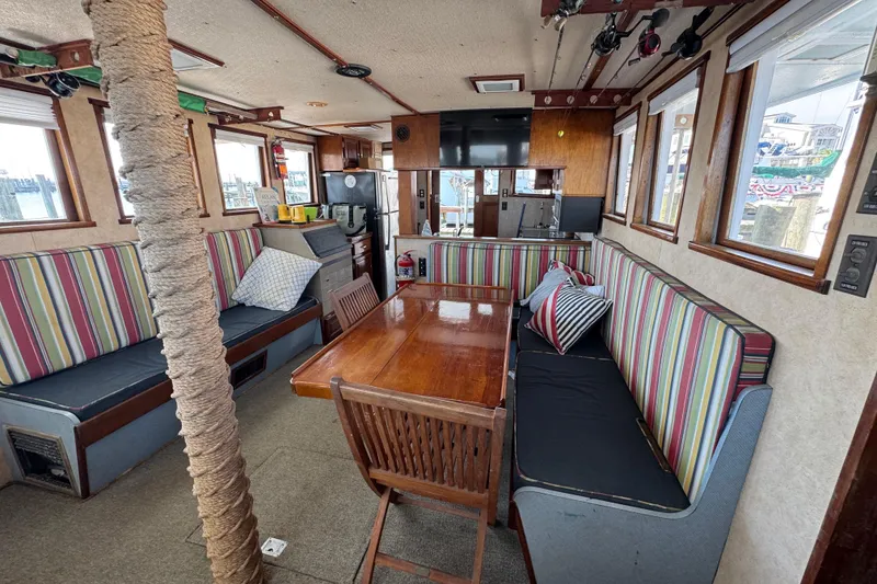 Slide: The Image of Interior of a 1985 custom Bill Holland trawler with striped seating and wooden table. - 11
