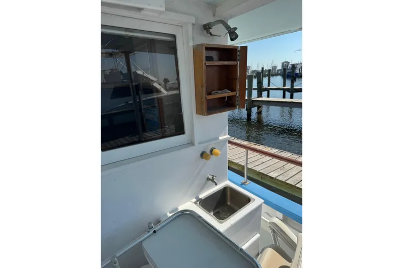 Slide: The Image of 1985 custom Bill Holland trawler with outdoor sink and storage, docked at marina. - 8