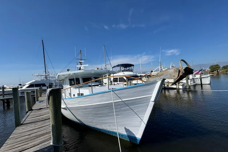Slide: The Image of Custom 1985 Bill Holland trawler docked at a marina under clear blue skies. - 3