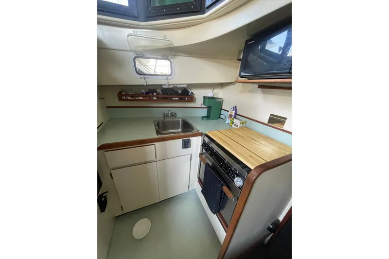 Slide: The Image of Compact kitchen in a 1992 Camano Troll Sedan 31 boat, featuring a sink and stove. - 11