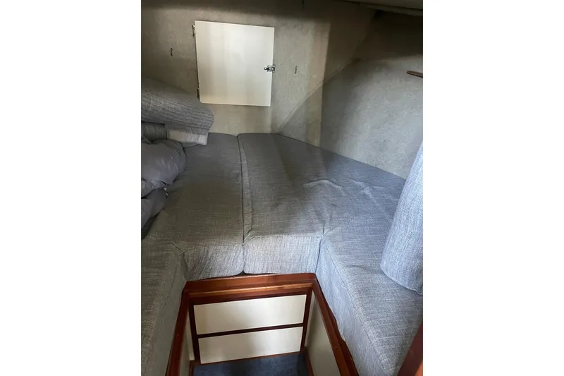Slide: The Image of Interior cabin of 1992 Camano Troll Sedan 31 with gray cushions and wooden accents. - 15