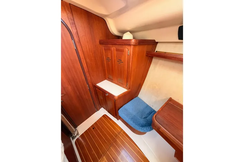 Slide: The Image of Interior of 1997 Hunter 430 sailboat with wooden cabinetry and blue cushioned seating. - 54