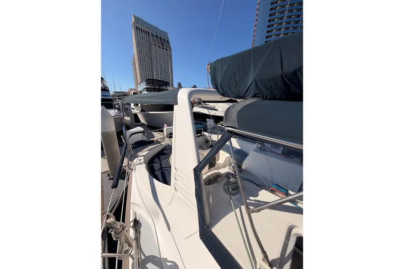 Slide: The Image of 1997 Hunter 430 sailboat docked in marina, with city buildings in background. - 27