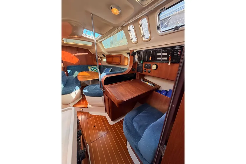 Slide: The Image of Interior of a 1997 Hunter 430 sailboat with wood paneling and blue seating. - 82