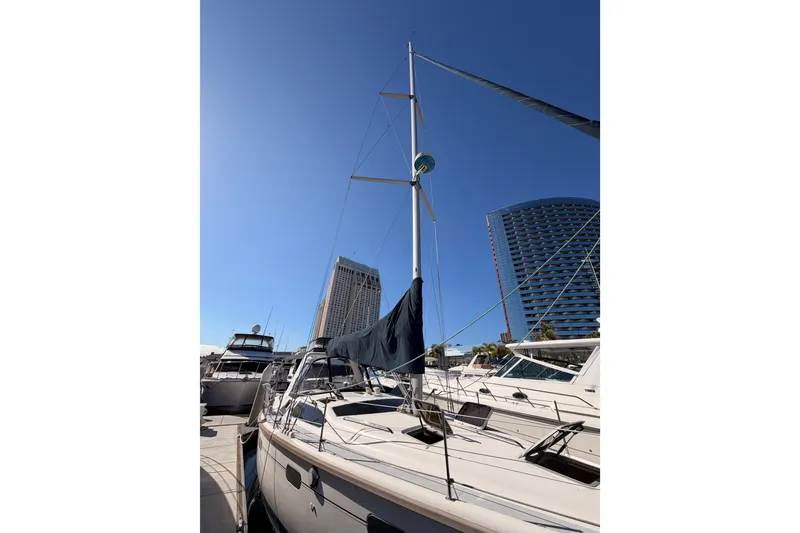 Slide: The Image of Sailboat Hunter 430, 1997 model, docked at marina with modern buildings in background. - 2