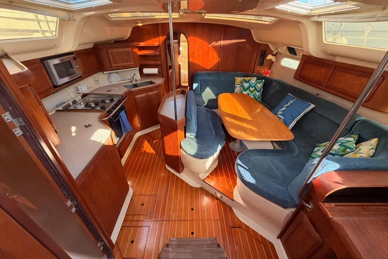 Slide: The Image of Interior of a 1997 Hunter 430 sailboat with cozy seating and a compact kitchen. - 33