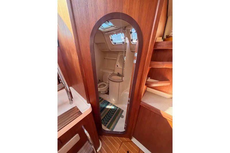 Slide: The Image of Interior of 1997 Hunter 430 sailboat showing bathroom with wooden cabinetry and nautical decor. - 69