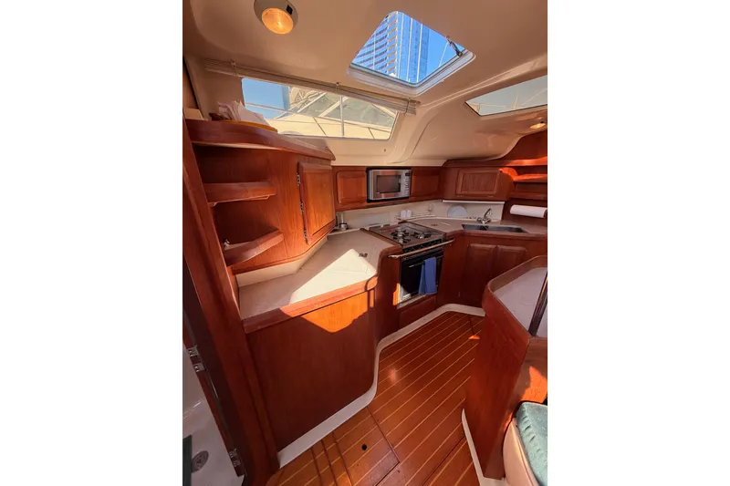 Slide: The Image of Interior of 1997 Hunter 430 yacht with wooden cabinetry and modern kitchen amenities. - 42