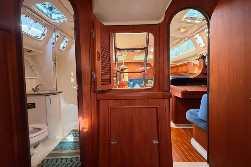 Slide: The Image of Interior of a 1997 Hunter 430 sailboat, featuring wood finishes and a compact bathroom. - 81