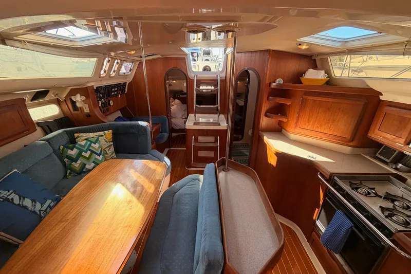 Slide: The Image of Interior of a 1997 Hunter 430 sailboat with cozy seating and wooden cabinetry. - 68