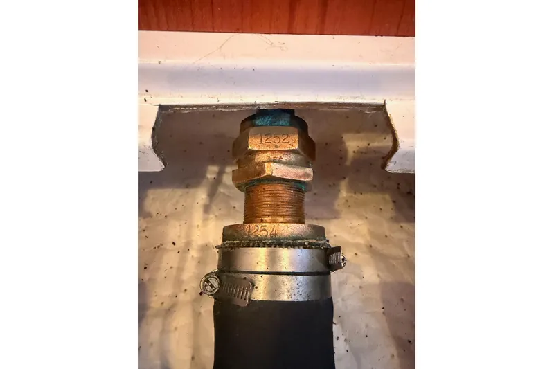 Slide: The Image of Close-up of a Hunter 430 boat fitting, showcasing a metal bolt and hose clamp. - 90