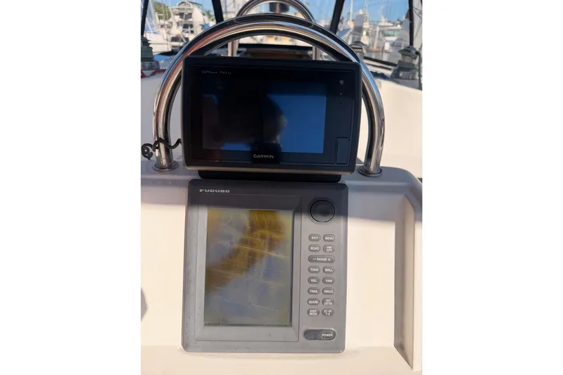 Slide: The Image of Garmin and Furuno navigation systems on a 1997 Hunter 430 sailboat dashboard. - 12