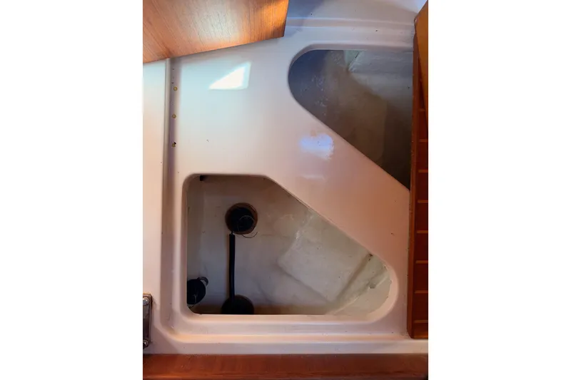 Slide: The Image of Interior compartment of a 1997 Hunter 430 sailboat, showcasing storage space and plumbing. - 94
