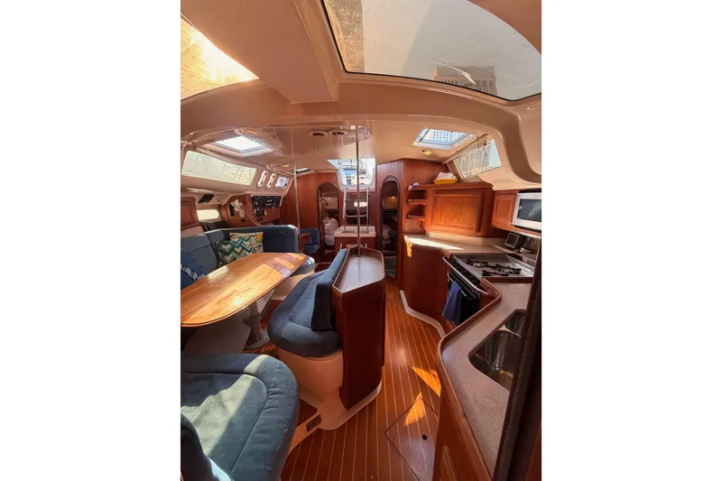 Slide: The Image of Interior of a 1997 Hunter 430 sailboat featuring a cozy dining area and kitchen. - 65