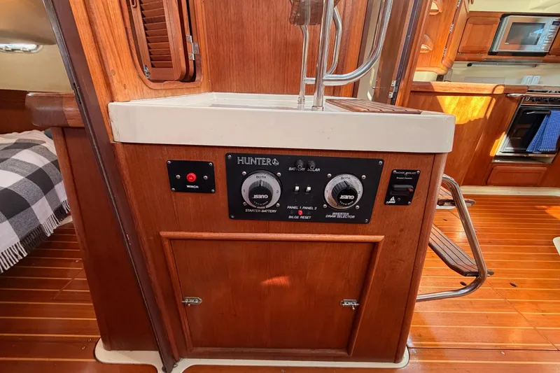Slide: The Image of Control panel inside a 1997 Hunter 430 sailboat, featuring wood cabinetry and electrical switches. - 39