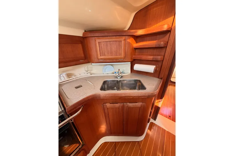 Slide: The Image of Compact wooden galley in 1997 Hunter 430 sailboat with sink and storage shelves. - 46