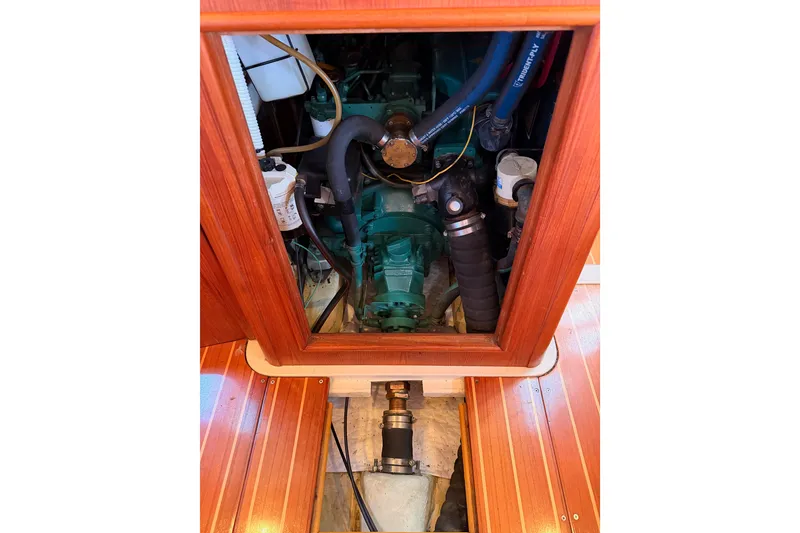 Slide: The Image of Engine compartment of a 1997 Hunter 430 sailboat, showcasing mechanical components and wooden paneling. - 88
