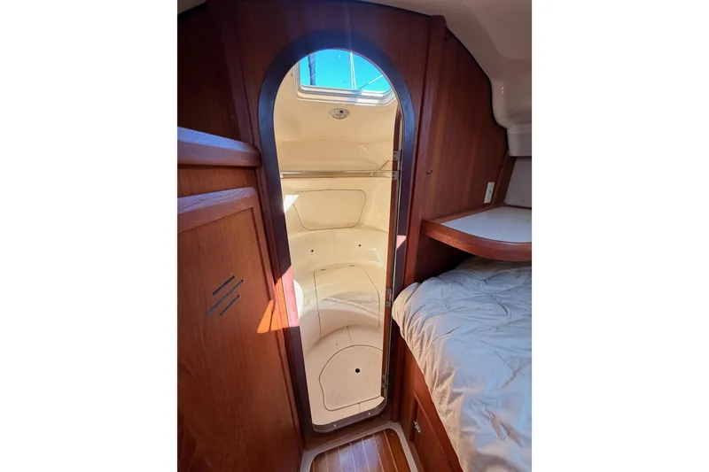 Slide: The Image of Interior cabin view of a 1997 Hunter 430 sailboat, featuring wood paneling and a cozy berth. - 57