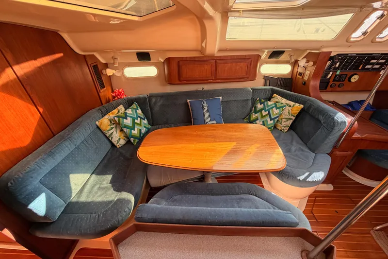 Slide: The Image of Interior of a 1997 Hunter 430 sailboat with cozy seating and colorful cushions. - 48