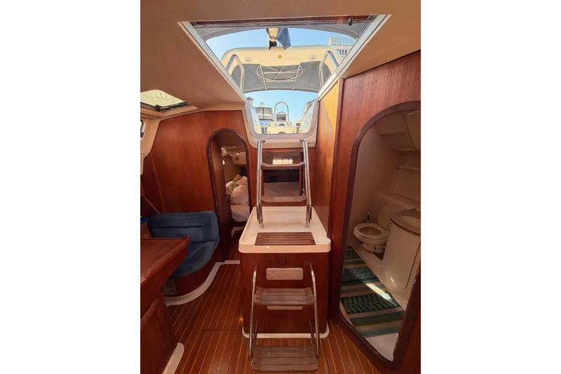 Slide: The Image of Interior of a 1997 Hunter 430 sailboat, featuring wooden finishes and a compact bathroom. - 84