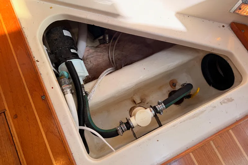 Slide: The Image of Bilge compartment of a 1997 Hunter 430 sailboat, showing plumbing and pump components. - 92