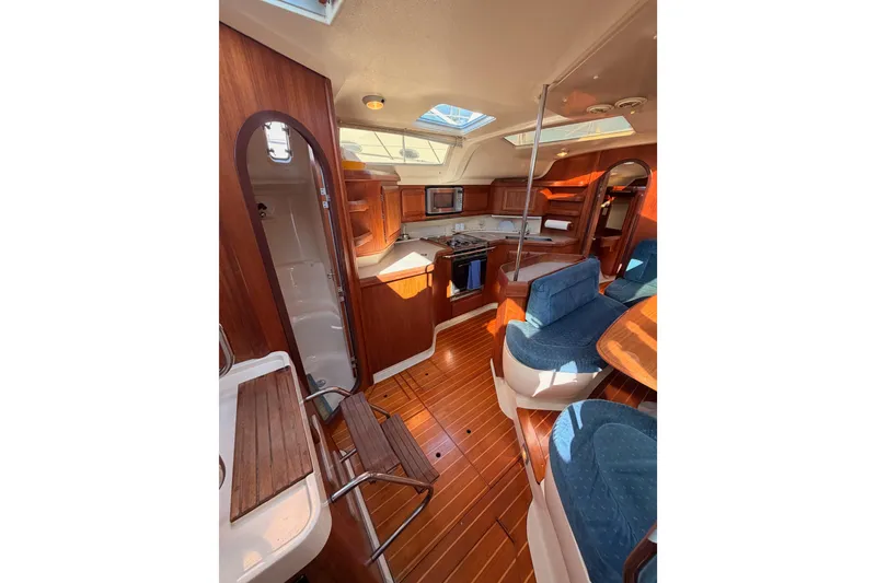 Slide: The Image of Interior of a 1997 Hunter 430 sailboat with wood finish and blue seating. - 40