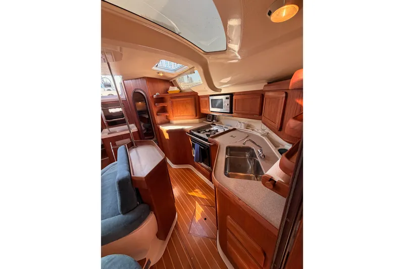 Slide: The Image of Interior of a 1997 Hunter 430 yacht with wooden cabinetry and modern amenities. - 67