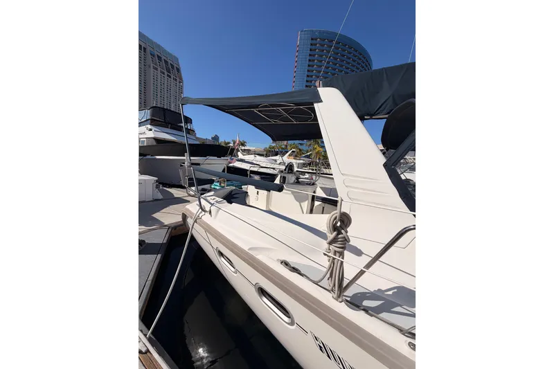 Slide: The Image of Hunter 430 sailboat from 1997 docked at a marina with modern buildings in the background. - 5