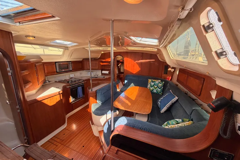 Slide: The Image of Interior of a 1997 Hunter 430 sailboat with cozy seating and wooden cabinetry. - 41
