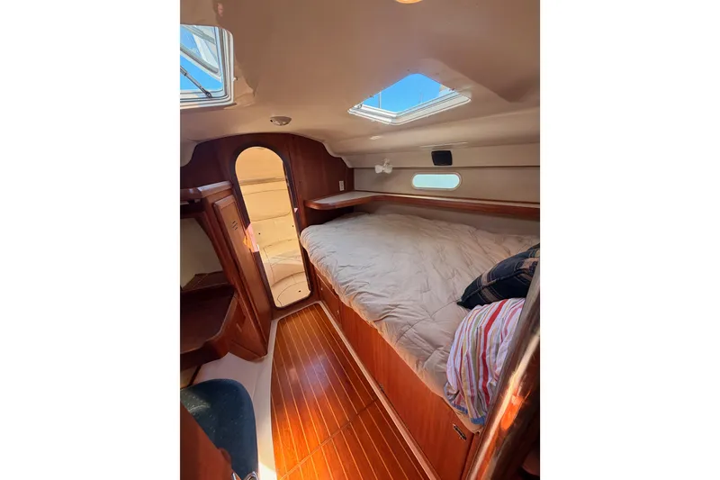 Slide: The Image of Cozy cabin interior of 1997 Hunter 430 sailboat with wooden flooring and bedding. - 52