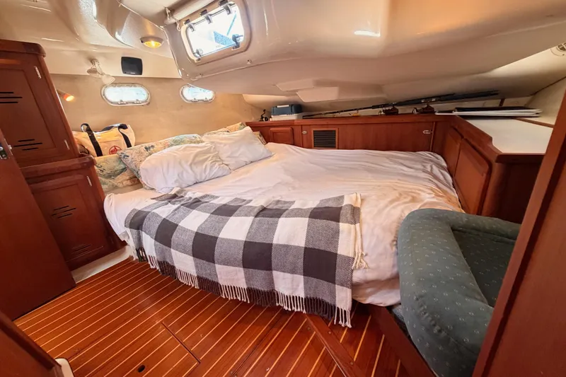 Slide: The Image of Cozy cabin interior of a 1997 Hunter 430 sailboat with a comfortable bed and wooden furnishings. - 75