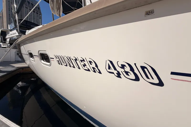 Slide: The Image of Hunter 430 sailboat from 1997 docked at a marina, showcasing its sleek design. - 4