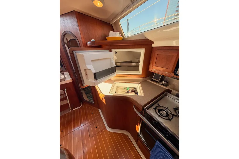 Slide: The Image of Interior of a 1997 Hunter 430 sailboat kitchen with wooden cabinetry and appliances. - 43