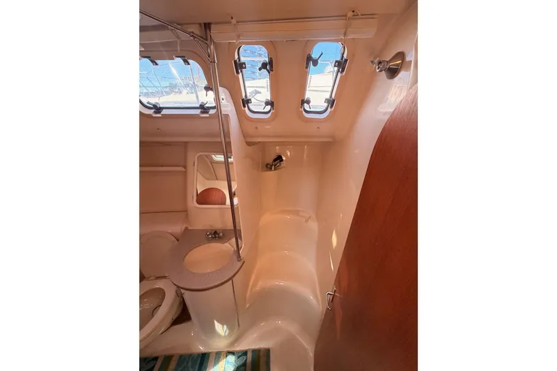Slide: The Image of Interior of 1997 Hunter 430 sailboat bathroom with portholes and compact design. - 71