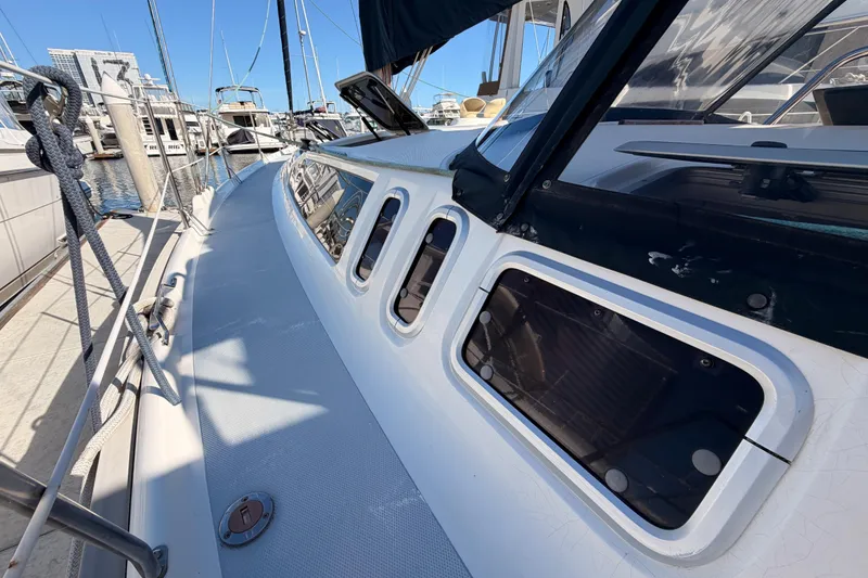 Slide: The Image of 1997 Hunter 430 sailboat docked, showcasing deck and cabin windows. - 17