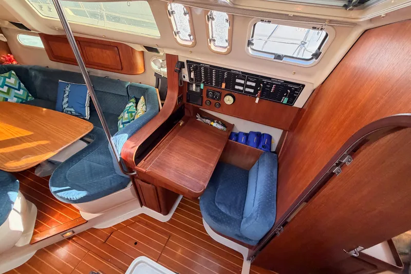 Slide: The Image of Interior of a 1997 Hunter 430 sailboat with wood finish and blue seating. - 34