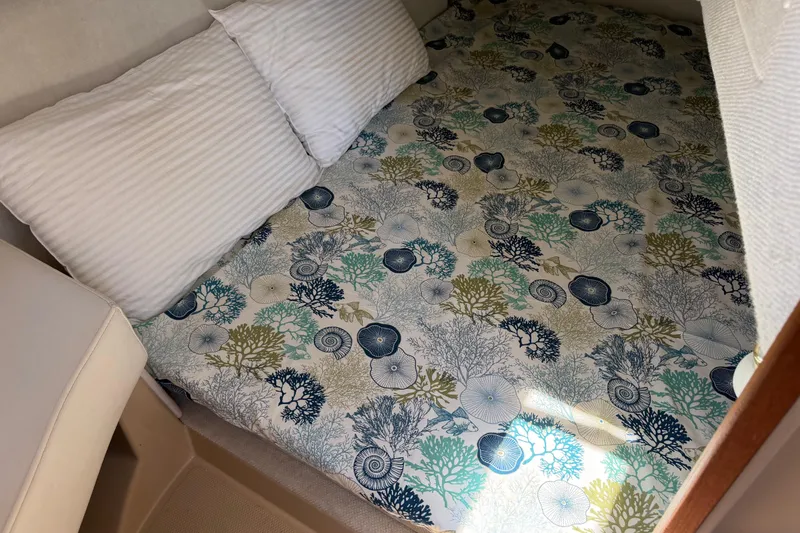 Slide: The Image of Cozy cabin bed in 2017 Ranger Tugs R-31 S with nautical-themed bedding. - 53