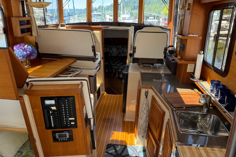 Slide: The Image of Interior of a 2017 Ranger Tugs R-31 S boat, featuring a cozy kitchen and seating area. - 11