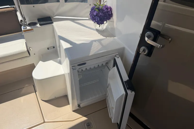 Slide: The Image of 2017 Ranger Tugs R-31 S interior with open mini fridge and purple flowers. - 9