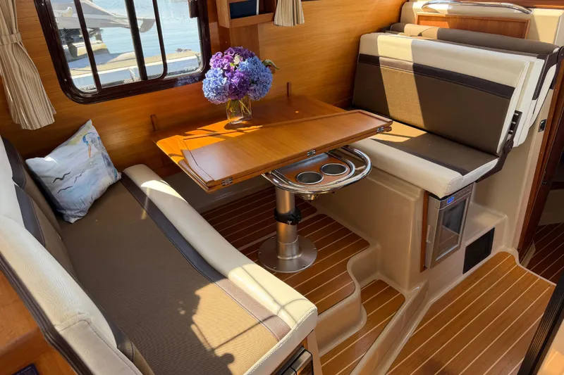 Slide: The Image of 2017 Ranger Tugs R-31 S interior with dining area, wooden table, and floral centerpiece. - 22