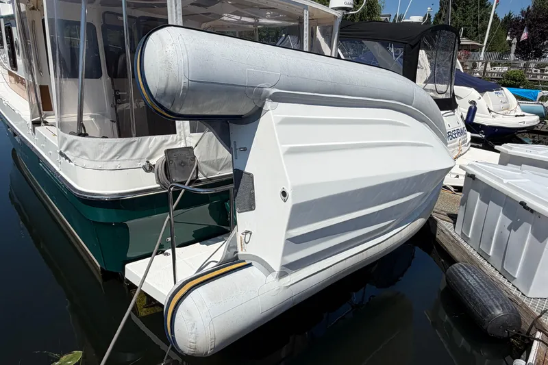 Slide: The Image of 2017 Ranger Tugs R-31 S with inflatable dinghy docked at marina. - 71