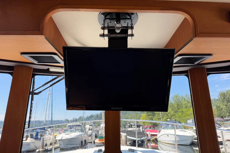 Slide: The Image of Interior of 2017 Ranger Tugs R-31 S with mounted TV and marina view. - 39