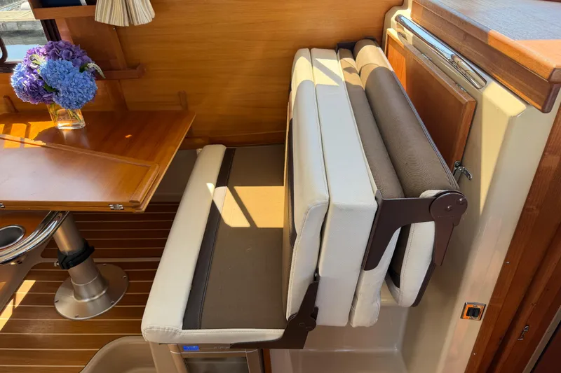 Slide: The Image of Interior of 2017 Ranger Tugs R-31 S with foldable seating and wooden table. - 21